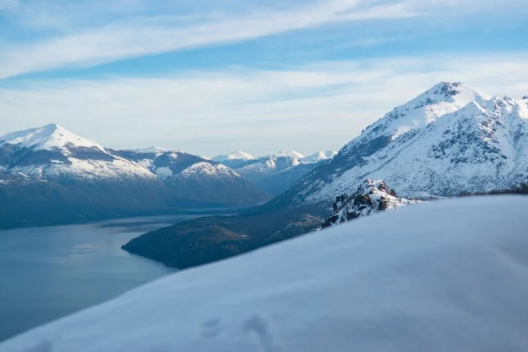 Neve nas montanhas à beira do lago, em Bariloche