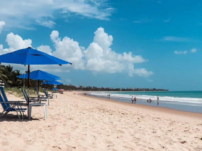 Guarda-sóis azuis na areia de uma praia da Paraíba.