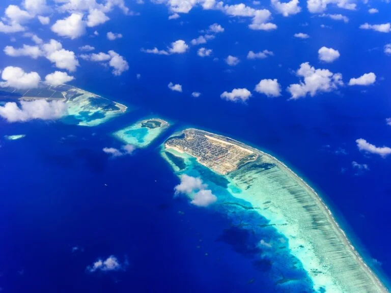Um atol visto do hidroavião: ilha, recife e mar de piscina