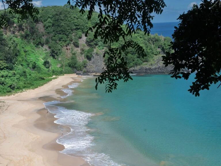 Enseada de areia clara e mar verde